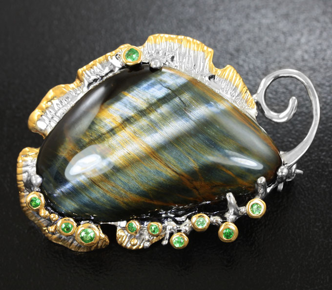 Серебряная брошь с тигровым глазом и цаворитами