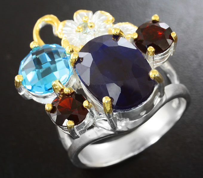 Серебряное кольцо с насыщенно-синим сапфиром, голубым топазом и гранатами