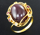 Золотое кольцо с крупным кабошоном рубина 20,39 карата, рубиновыми шпинелями бриллиантовой огранки и лейкосапфирами Золото