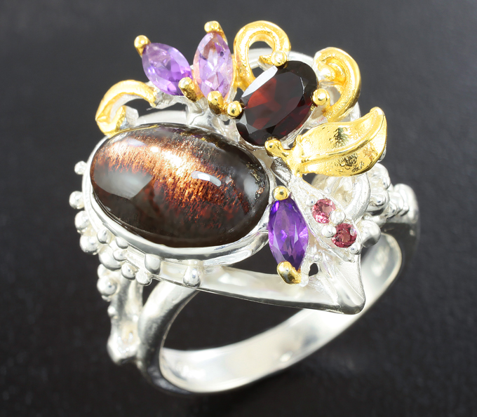Серебряное кольцо с черным солнечным камнем с эффектом кошачьего глаза, аметистами и гранатами