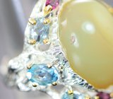Серебряное кольцо с желтым опалом 20,91 карата, голубыми топазами, родолитами и перидотом