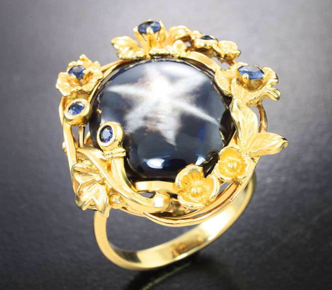 Массивное золотое кольцо с крупным звездчатым 27,59 карата и синими сапфирами