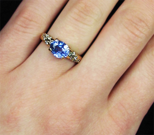 Сапфир на пальце. Золотое кольцо с голубым сапфиром. Золотое кольцо с синим камнем. Кольцо голубым маленьким камушками.