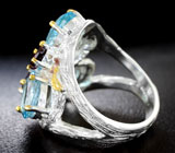 Серебряное кольцо с голубыми топазами и родолитами